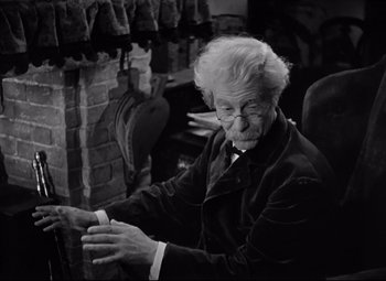 Movie still from “Goodbye, Mr. Chips” (1939), directed by Sam Wood – An old man sitting in front of a fireplace; Medium shot, High angle