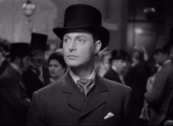 Movie still from “Goodbye, Mr. Chips” (1939), directed by Sam Wood – A black and white photo of a man wearing a top hat; Close Up shot, Low angle