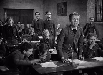 Movie still from “Goodbye, Mr. Chips” (1939), directed by Sam Wood – A group of young people sitting at a table; Medium shot, Low angle