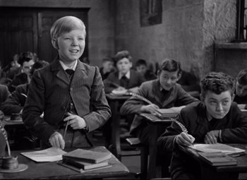 Movie still from “Goodbye, Mr. Chips” (1939), directed by Sam Wood – Black and white photograph of a boy in a classroom; Medium shot, High angle