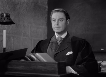 Movie still from “Goodbye, Mr. Chips” (1939), directed by Sam Wood – A black and white photo of a man in a suit and tie; Medium shot, Low angle