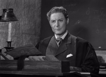 Movie still from “Goodbye, Mr. Chips” (1939), directed by Sam Wood – A black and white photo of a man in a suit and tie; Medium shot, High angle