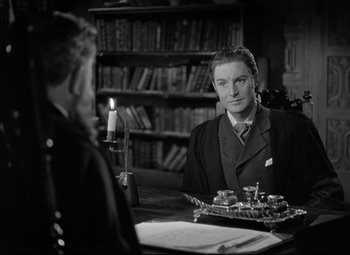 Movie still from “Goodbye, Mr. Chips” (1939), directed by Sam Wood – A man and a woman sitting at a table; Medium shot, Over the shoulder angle