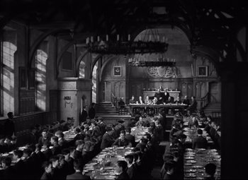 Movie still from “Goodbye, Mr. Chips” (1939), directed by Sam Wood – A group of people sitting at tables in a large room; Extreme Wide shot, High angle