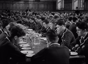 Movie still from “Goodbye, Mr. Chips” (1939), directed by Sam Wood – Black and white photograph of a group of people sitting at a table; Wide shot, High angle