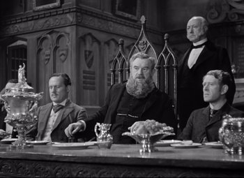 Movie still from “Goodbye, Mr. Chips” (1939), directed by Sam Wood – A black and white photo of a group of men sitting at a table; Medium shot, Low angle