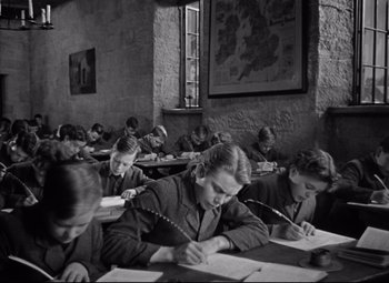 Movie still from “Goodbye, Mr. Chips” (1939), directed by Sam Wood – Black and white photograph of students writing at desks; Medium shot, High angle