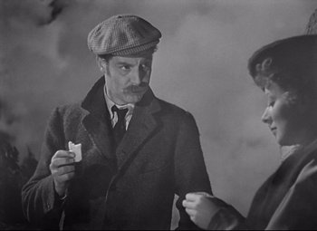 Movie still from “Goodbye, Mr. Chips” (1939), directed by Sam Wood – An old photo of a man and a woman; Medium shot, High angle