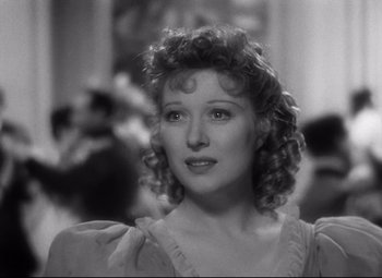 Movie still from “Goodbye, Mr. Chips” (1939), directed by Sam Wood – An old photo of a woman with curly hair looking to her left; Close Up shot, Over the shoulder angle