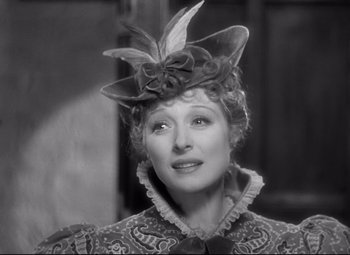 Movie still from “Goodbye, Mr. Chips” (1939), directed by Sam Wood – An old photo of a woman wearing a fancy hat; Close Up shot, Over the shoulder angle