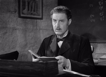 Movie still from “Goodbye, Mr. Chips” (1939), directed by Sam Wood – A black and white photo of a man reading a book; Medium shot, High angle
