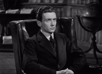 Movie still from “Goodbye, Mr. Chips” (1939), directed by Sam Wood – A black and white photo of a man sitting in a chair; Medium shot, High angle