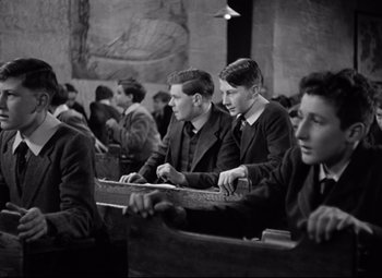 Movie still from “Goodbye, Mr. Chips” (1939), directed by Sam Wood – Black and white photograph of young men sitting in a church; Medium shot, High angle