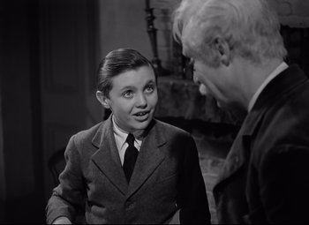 Movie still from “Goodbye, Mr. Chips” (1939), directed by Sam Wood – An older man and a young girl in a room; Medium shot, Over the shoulder angle