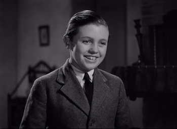 Movie still from “Goodbye, Mr. Chips” (1939), directed by Sam Wood – A young man in a suit and tie; Close Up shot, High angle
