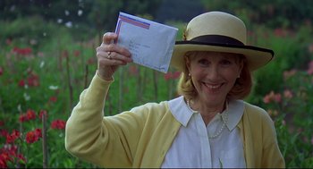 Movie still from “Gorillas in the Mist” (1988), directed by Michael Apted – An older woman holding an envelope in her hand; Close Up shot, Low angle