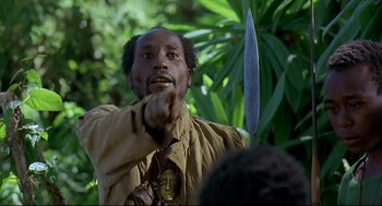Movie still from “Gorillas in the Mist” (1988), directed by Michael Apted – A man holding a knife in his right hand; Close Up shot, Over the shoulder angle