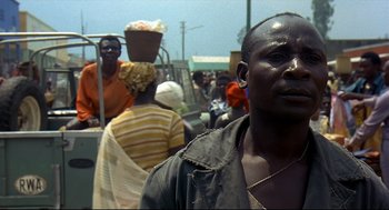 Movie still from “Gorillas in the Mist” (1988), directed by Michael Apted – A group of people walking down a street; Close Up shot, Over the shoulder angle