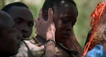 Movie still from “Gorillas in the Mist” (1988), directed by Michael Apted – A person touching the face of another person in front of a tree; Close Up shot, Over the shoulder angle