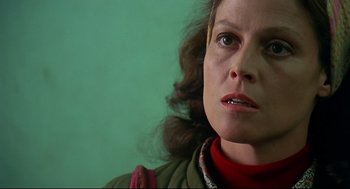 Movie still from “Gorillas in the Mist” (1988), directed by Michael Apted – A woman's face with a green background; Close Up shot, Low angle