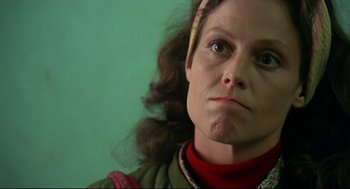 Movie still from “Gorillas in the Mist” (1988), directed by Michael Apted – A woman's face with a green background; Close Up shot, Low angle