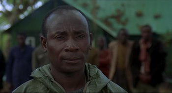 Movie still from “Gorillas in the Mist” (1988), directed by Michael Apted – A person wearing a green jacket; Close Up shot, Over the shoulder angle