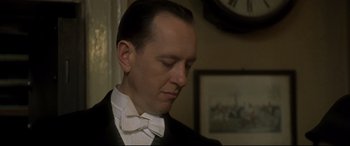 Movie still from “Gosford Park” (2001), directed by Robert Altman – A person wearing a suit and bow tie; Close Up shot, Low angle