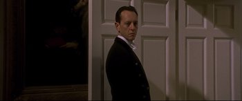 Movie still from “Gosford Park” (2001), directed by Robert Altman – A man standing in front of a white door; Close Up shot, Low angle