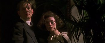 Movie still from “Gosford Park” (2001), directed by Robert Altman – A man and a woman standing next to each other in front of a palm tree; Close Up shot, Low angle