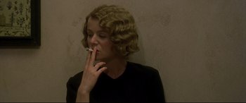 Movie still from “Gosford Park” (2001), directed by Robert Altman – A woman is smoking a cigarette in a room; Close Up shot, Low angle