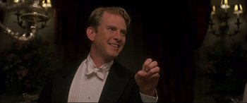 Movie still from “Gosford Park” (2001), directed by Robert Altman – A man in a tuxedo clapping his hands; Close Up shot, Low angle