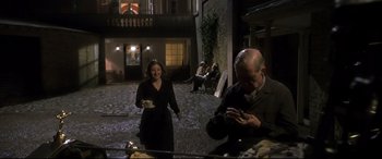 Movie still from “Gosford Park” (2001), directed by Robert Altman – An older man and a young woman are eating outside; Wide shot, Over the shoulder angle