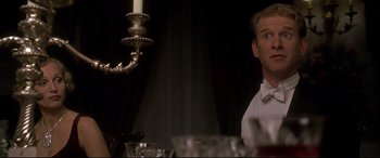 Movie still from “Gosford Park” (2001), directed by Robert Altman – A man sitting at a dinner table with a candle in the background; Close Up shot, Low angle