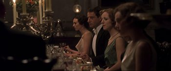 Movie still from “Gosford Park” (2001), directed by Robert Altman – A group of people sitting at a long table with food; Medium shot, Over the shoulder angle