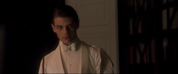 Movie still from “Gosford Park” (2001), directed by Robert Altman – A young man in a white tuxedo standing in a room; Close Up shot, Low angle