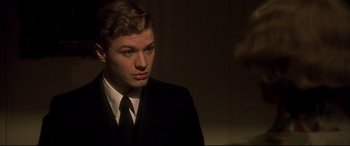 Movie still from “Gosford Park” (2001), directed by Robert Altman – A man in a suit and tie looking to his left; Close Up shot, Over the shoulder angle