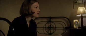 Movie still from “Gosford Park” (2001), directed by Robert Altman – A woman with short brown hair is standing in front of an iron bed; Close Up shot, Over the shoulder angle