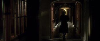 Movie still from “Gosford Park” (2001), directed by Robert Altman – A person walking down a hallway in the dark; Wide shot, Low angle