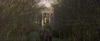Movie still from “Gosford Park” (2001), directed by Robert Altman – A group of elephants walking through a forest; Extreme Wide shot, High angle