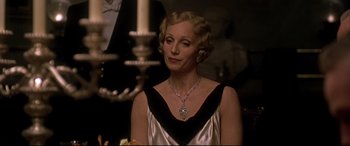 Movie still from “Gosford Park” (2001), directed by Robert Altman – An older woman wearing a silver dress and a necklace; Close Up shot, Over the shoulder angle