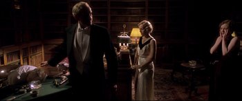 Movie still from “Gosford Park” (2001), directed by Robert Altman – A man and a woman standing in front of a bookshelf; Medium shot, Low angle