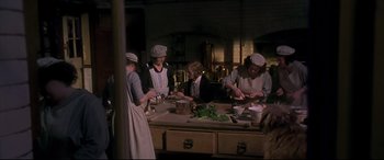 Movie still from “Gosford Park” (2001), directed by Robert Altman – A group of people are preparing food in a kitchen; Medium shot, High angle