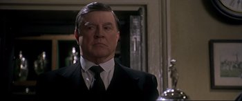 Movie still from “Gosford Park” (2001), directed by Robert Altman – A man in a suit and a tie; Close Up shot, Low angle