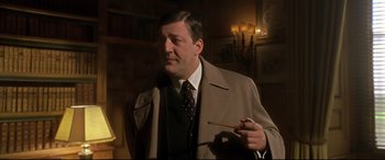 Movie still from “Gosford Park” (2001), directed by Robert Altman – A man in a suit and tie smoking a cigarette; Close Up shot, Over the shoulder angle