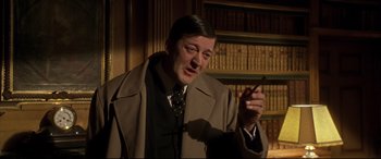 Movie still from “Gosford Park” (2001), directed by Robert Altman – A man in a suit and tie smoking a cigarette; Close Up shot, Low angle