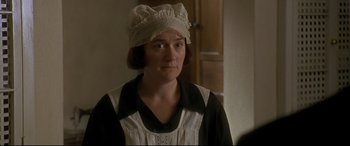 Movie still from “Gosford Park” (2001), directed by Robert Altman – A woman wearing a white hat and a black apron; Close Up shot, Over the shoulder angle