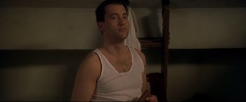 Movie still from “Gosford Park” (2001), directed by Robert Altman – A man in a white shirt holding a wooden stick; Medium shot, Low angle