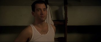 Movie still from “Gosford Park” (2001), directed by Robert Altman – A man in a white tank top looking at the camera; Close Up shot, Low angle
