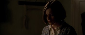 Movie still from “Gosford Park” (2001), directed by Robert Altman – A woman in a white shirt and a blue and yellow jacket; Close Up shot, Over the shoulder angle