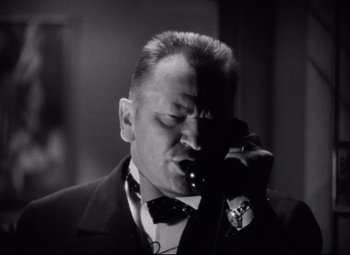 Movie still from “Grand Hotel” (1932), directed by Edmund Goulding – A black and white photo of a man talking on a phone; Close Up shot, Low angle